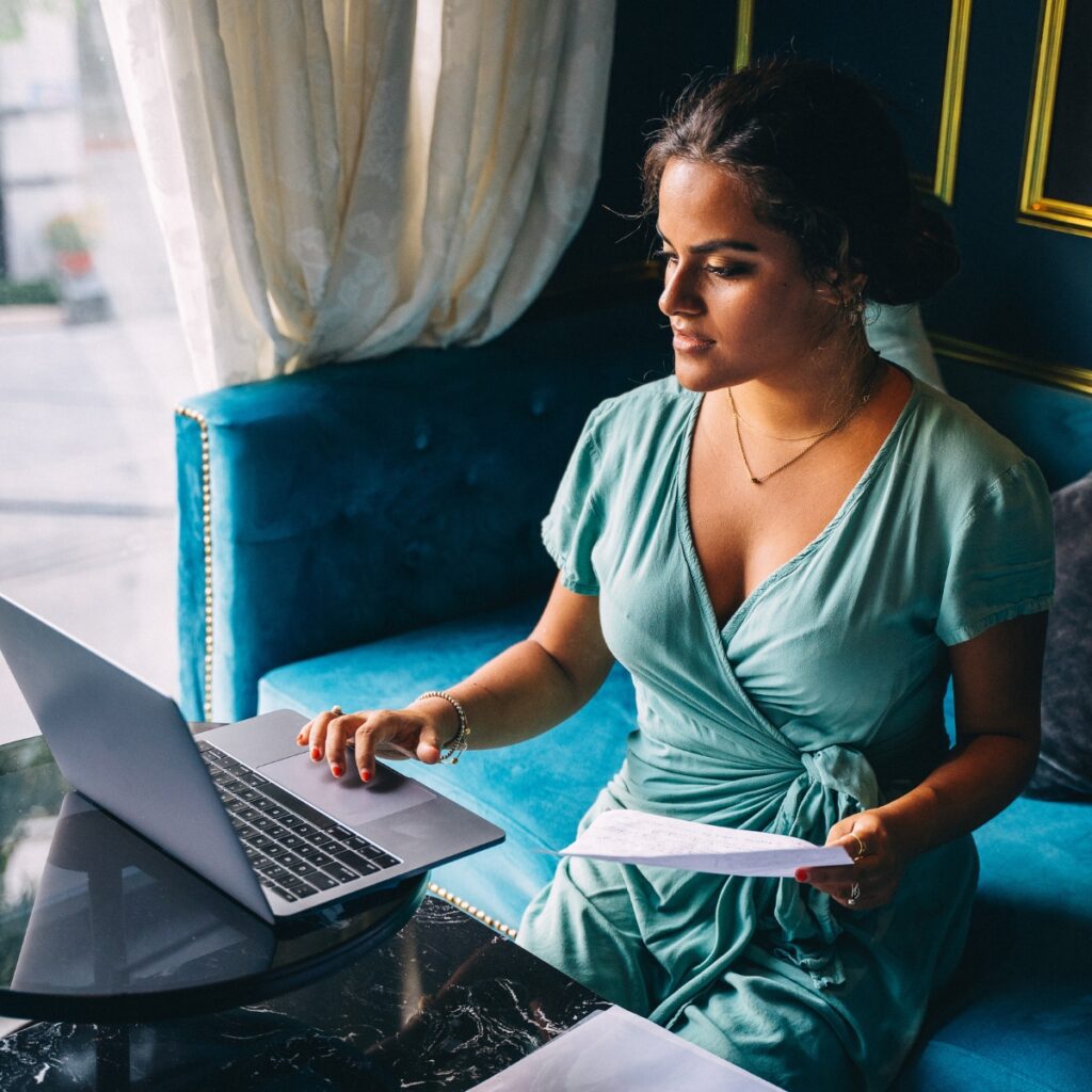 Woman on a blue couch reading a blogging contract closely.